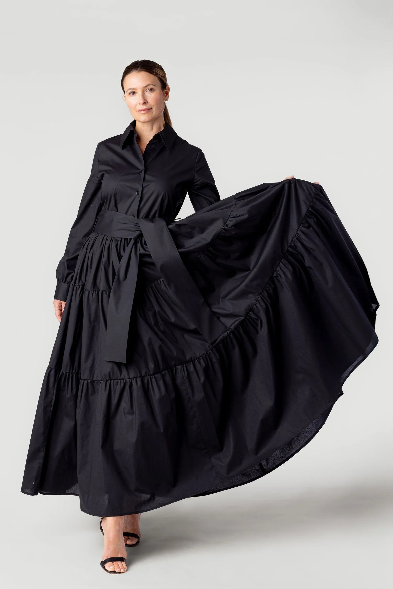 Woman wearing a black dress with a flowing skirt on a white background
