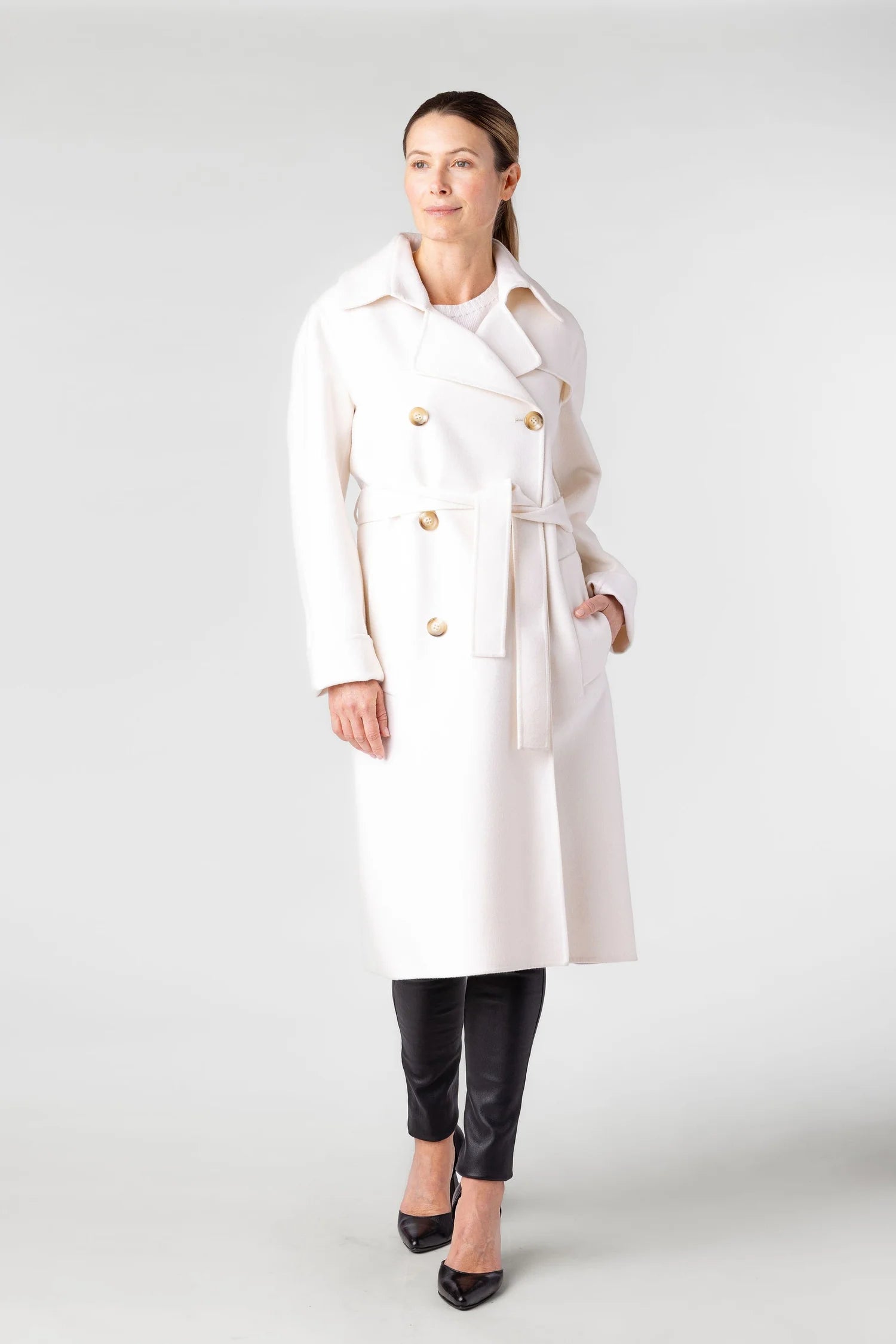 Woman wearing a white trench coat on a white background