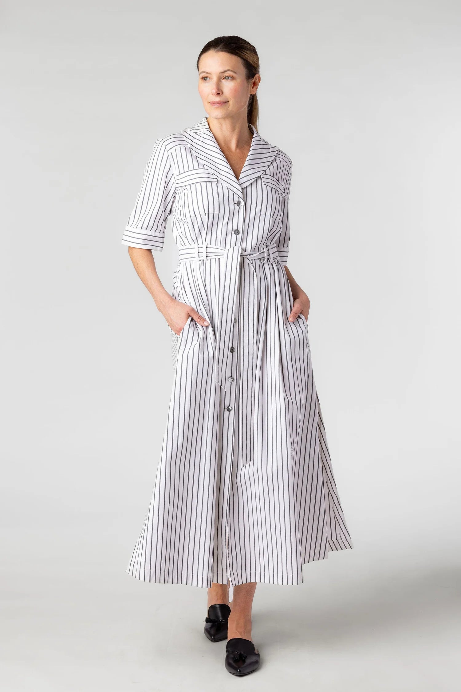 Woman wearing a striped dress on a plain background
