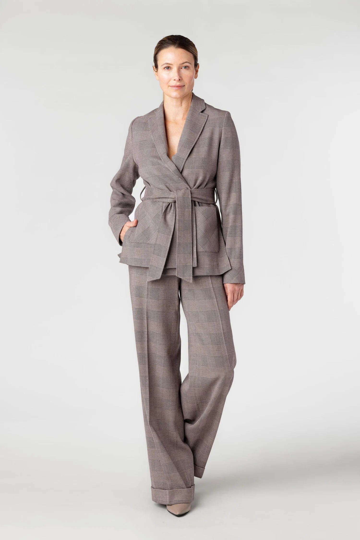 Woman wearing a gray checkered suit on a white background