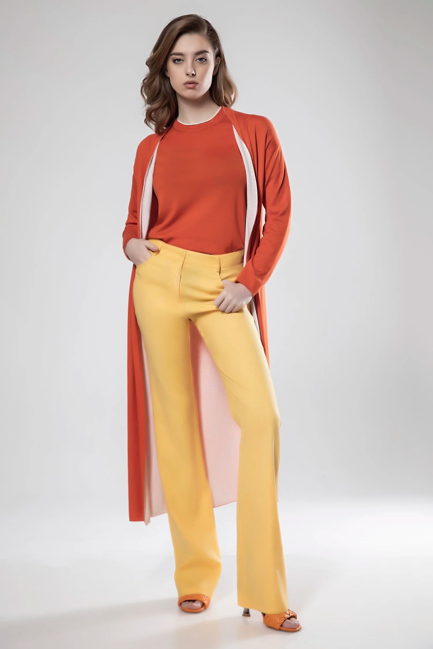 Woman wearing a red top and yellow pants on a white background