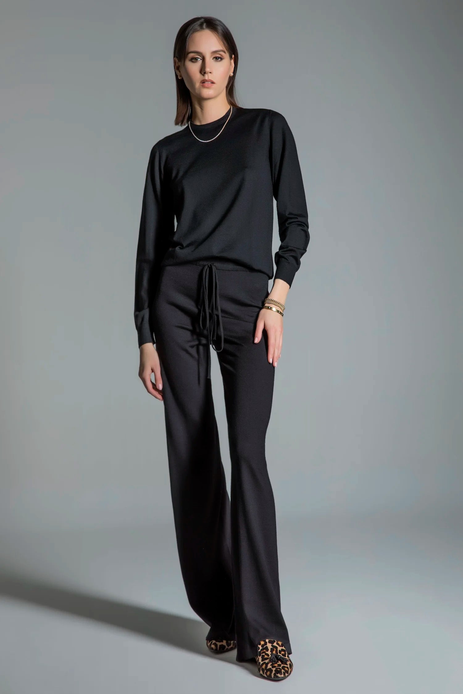 Woman wearing a black outfit with a plain background