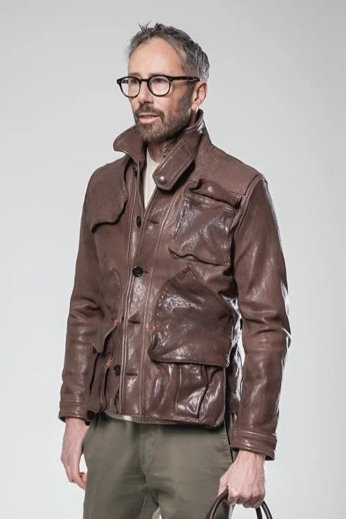 Man wearing a brown leather jacket on a plain background