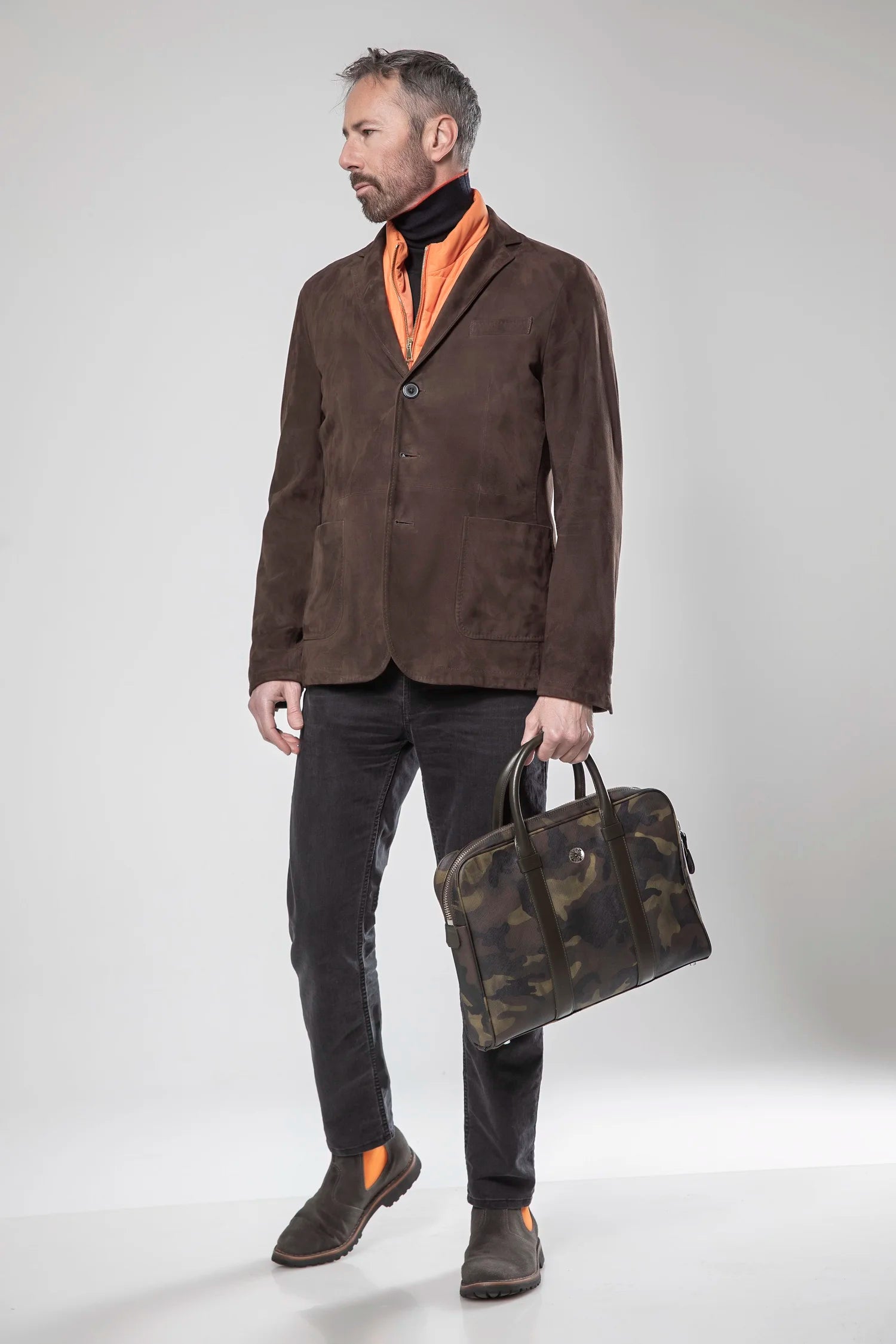 Man holding a camouflage briefcase against a white background