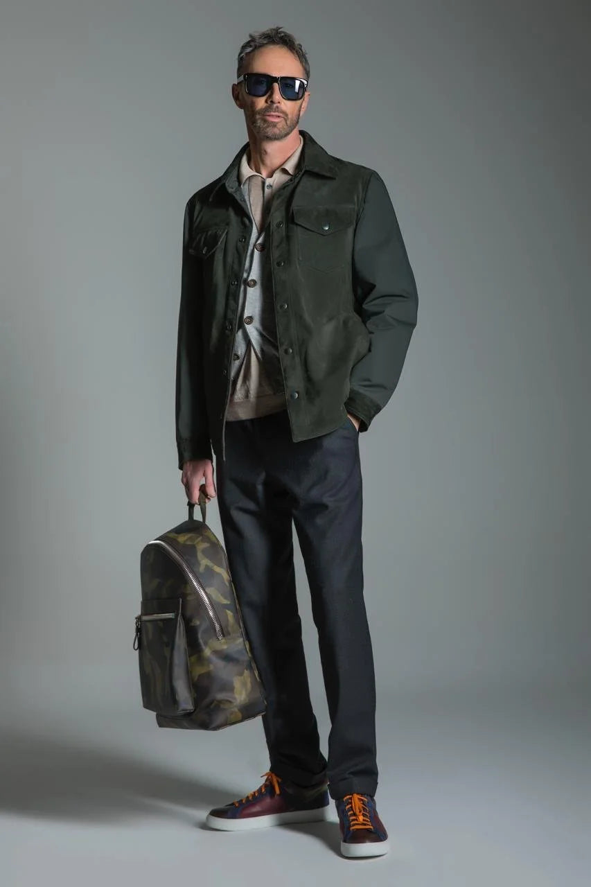 Man holding a patterned bag against a gray background