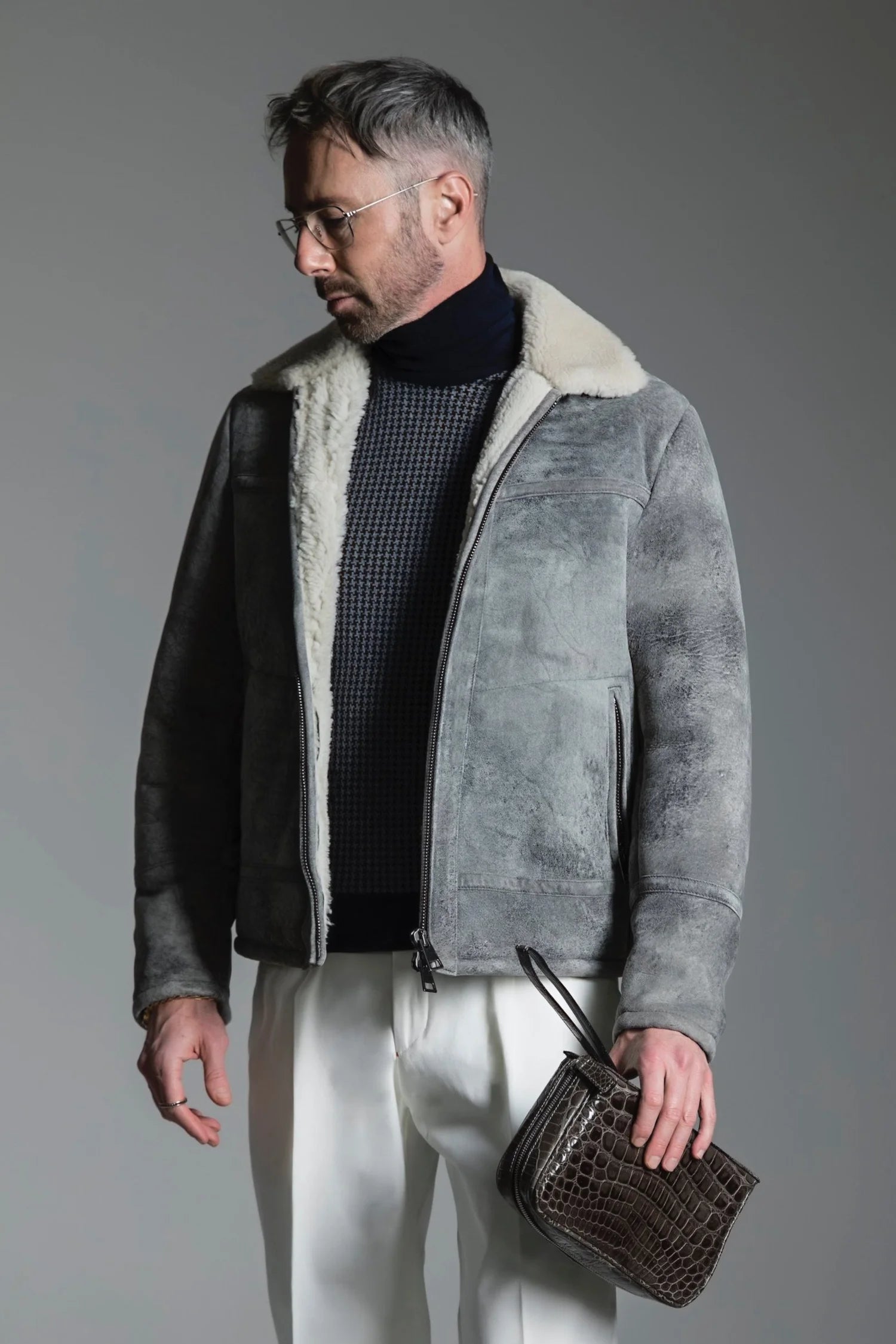 Man wearing a gray shearling jacket with a white background